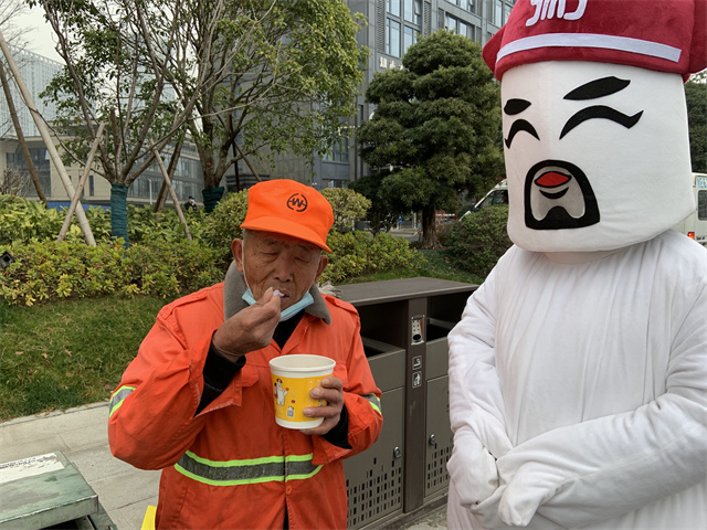 粥大白將臘八粥送至環(huán)衛(wèi)工人們的手中